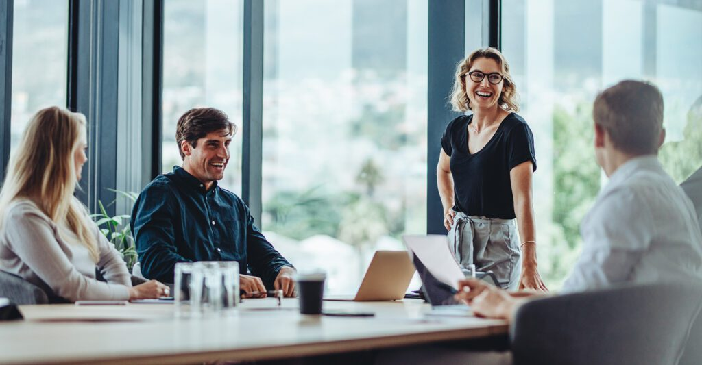 A manager leading a discussion with colleagues in a modern workplace
